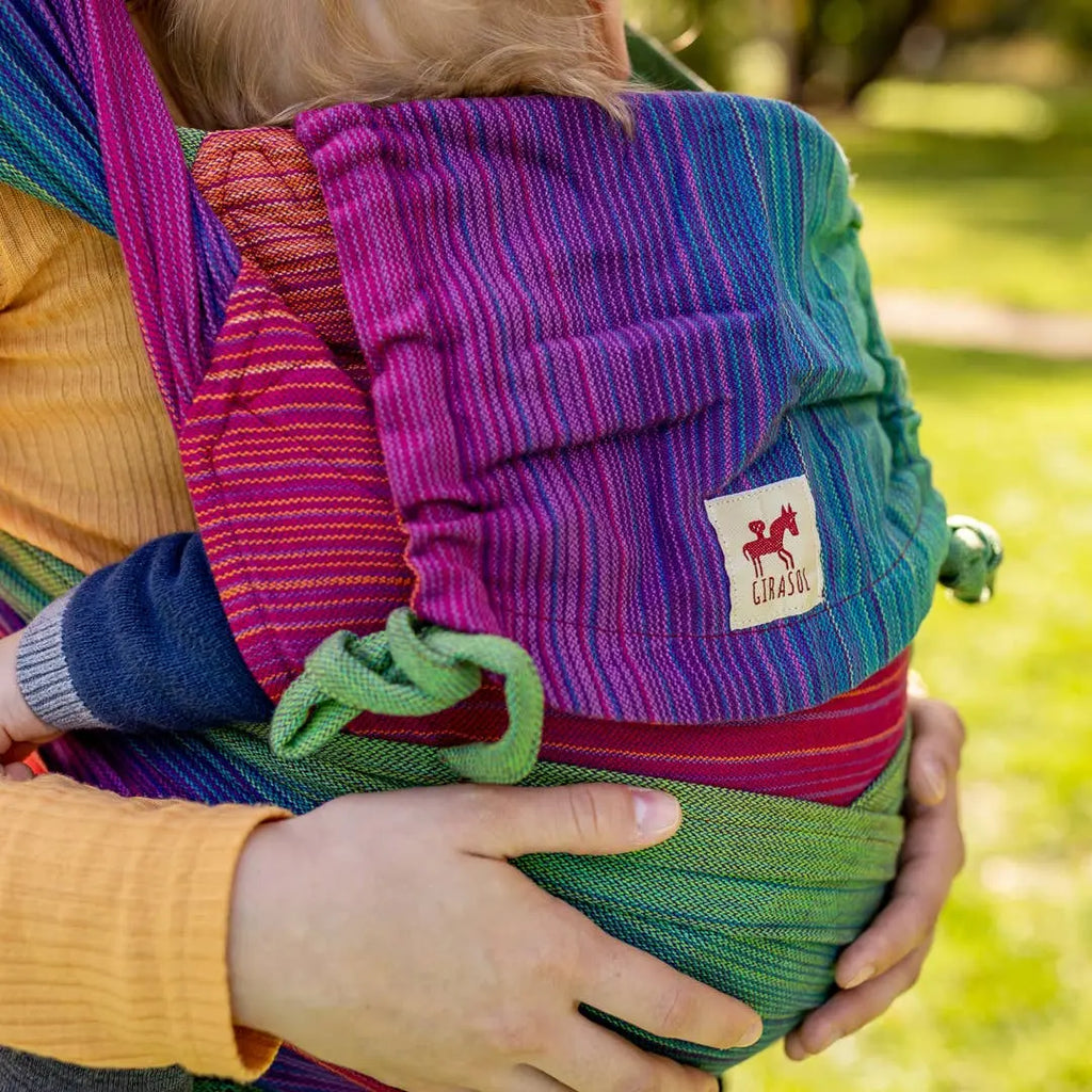 Girasol WrapMySol Paradise close-up on baby — vibrant multicolor stripe handwoven cotton half buckle Mei Tai Meh Dai
